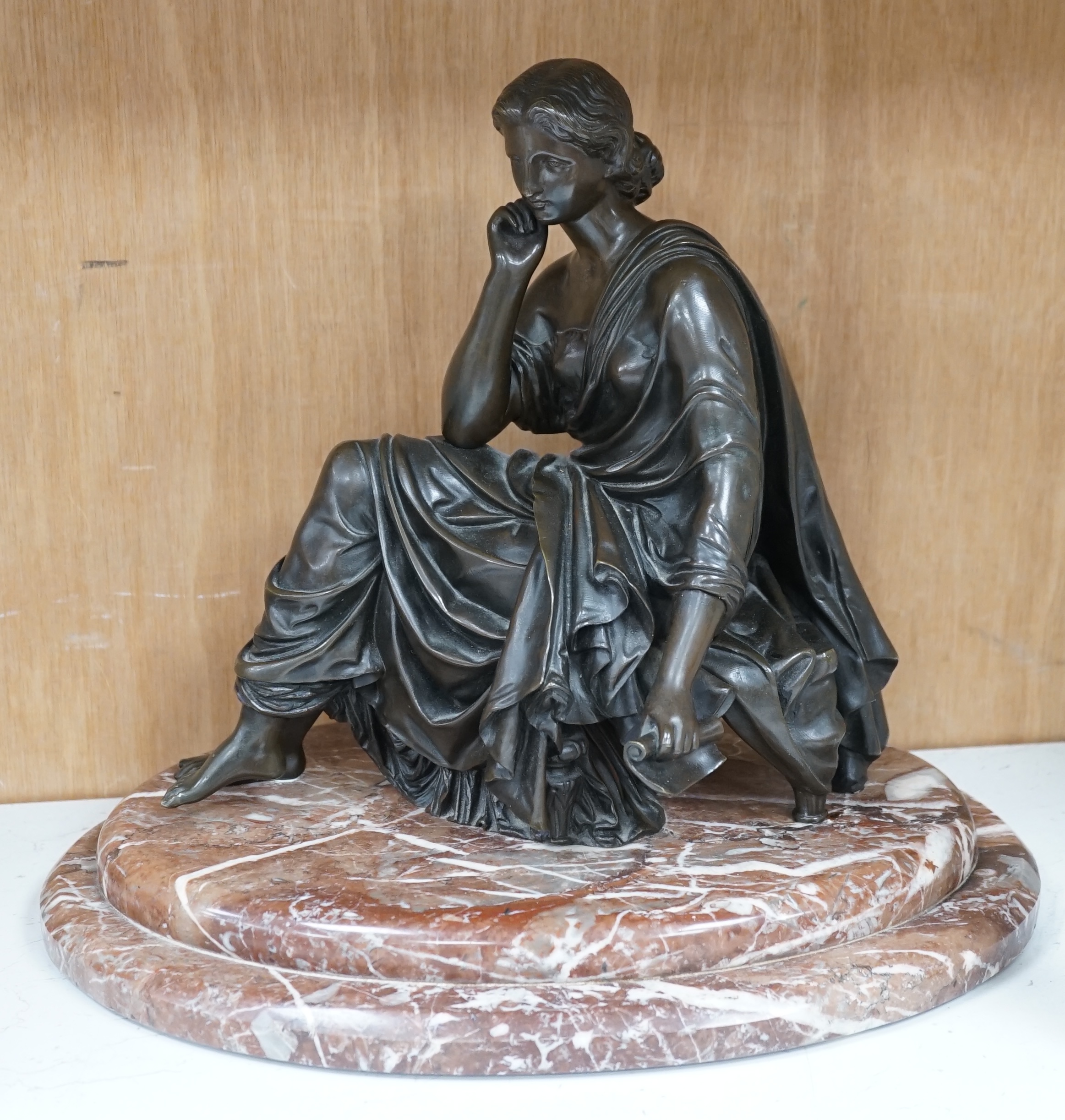 A Continental bronze of a seated young woman on a rouge marble base 37cm wide. Condition - good